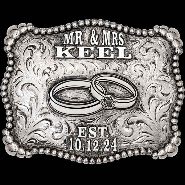 "The monochromatic design of our Silverado Belt Buckle is simply classic and leaves the story to be told with memories of your Special Day. This Buckle is crafted on a hand-engraved, German Silver base with a light antique finish. It is detailed with